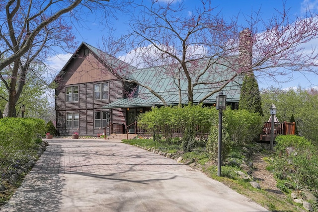 view of front of property with metal roof, driveway, and a standing seam roof
