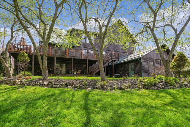 rear view of property featuring a standing seam roof, metal roof, a lawn, and a deck
