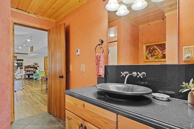 bathroom with tile patterned flooring, wooden ceiling, and vanity