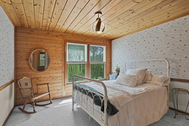carpeted bedroom featuring baseboards, wood ceiling, and wallpapered walls