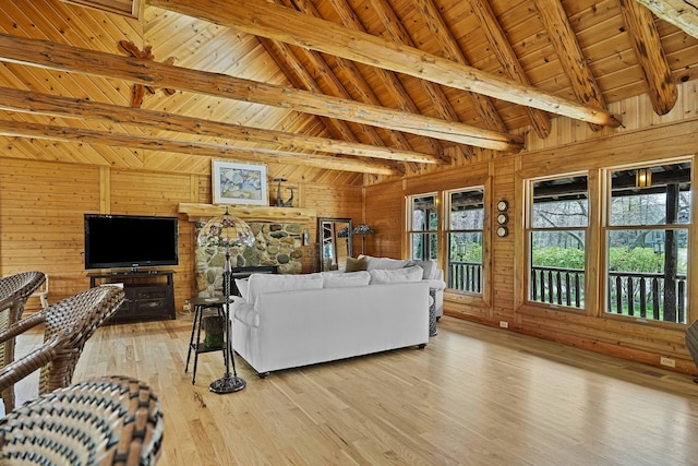 living room with vaulted ceiling with beams, wood walls, wooden ceiling, and light wood-style flooring