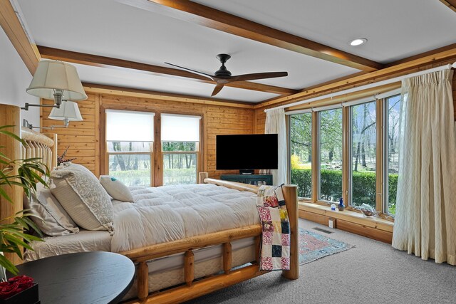 bedroom featuring carpet floors, wood walls, visible vents, and beamed ceiling