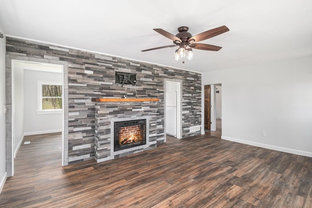 unfurnished living room featuring a tiled fireplace, a ceiling fan, baseboards, and wood finished floors