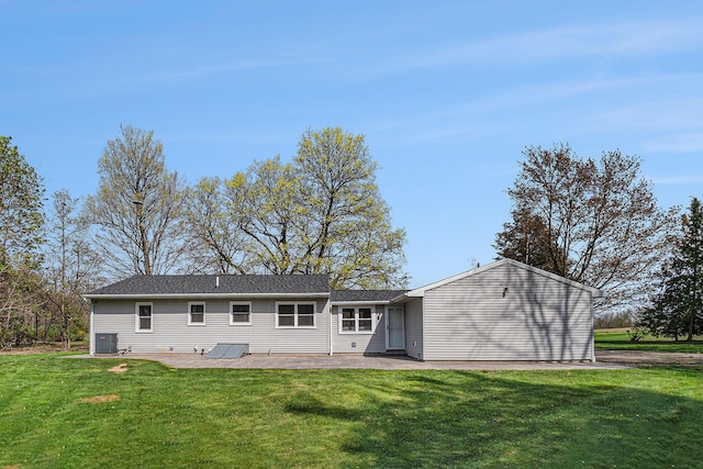 back of property with a yard, a patio area, and central AC