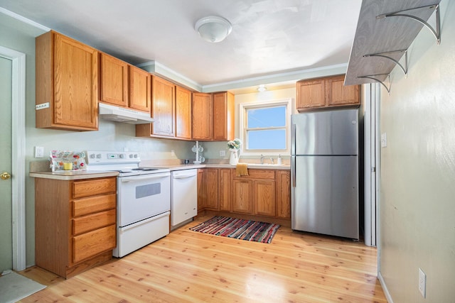 kitchen featuring white appliances, light countertops, brown cabinetry, light wood-style flooring, and under cabinet range hood
