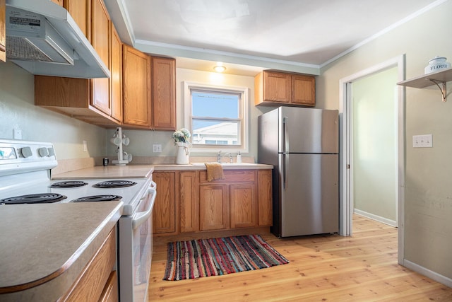 kitchen featuring crown molding, freestanding refrigerator, under cabinet range hood, and electric stove