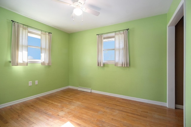 unfurnished room with visible vents, a ceiling fan, baseboards, and light wood finished floors