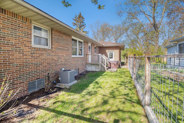 view of yard featuring central AC and fence