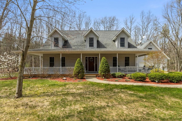 view of front of home with roof with shingles, a porch, and a front lawn