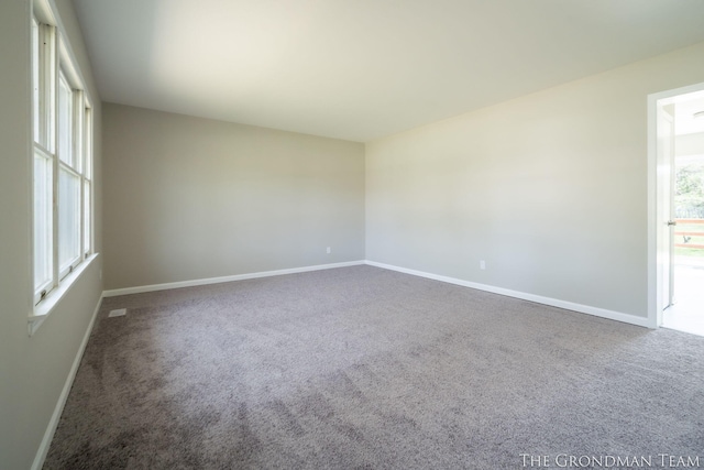 carpeted spare room featuring baseboards