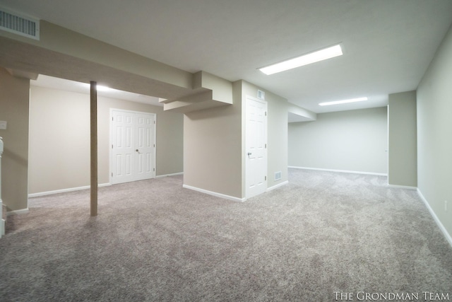 finished basement featuring visible vents, carpet flooring, and baseboards