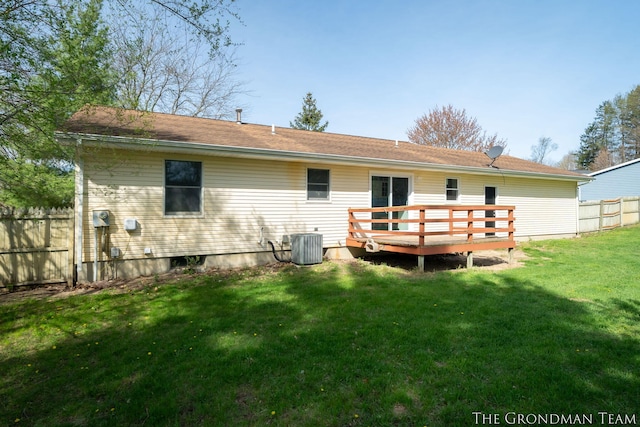 back of house with fence, a wooden deck, and a yard