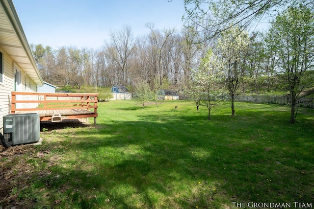 view of yard featuring central air condition unit, a wooden deck, and a fenced backyard