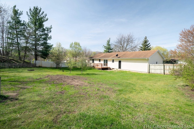 view of yard with a fenced backyard and a wooden deck