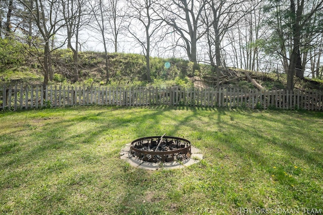 view of yard featuring a fenced backyard and a fire pit