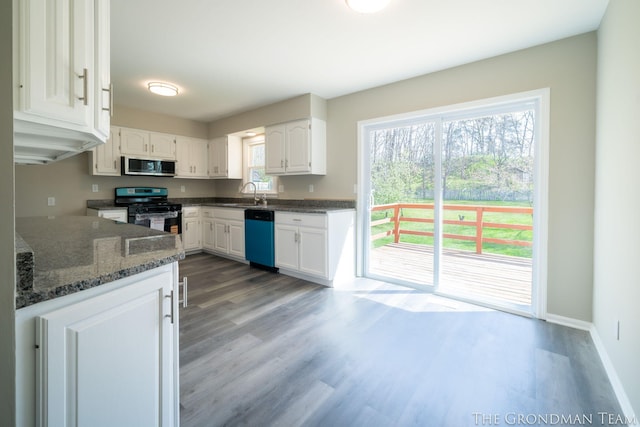 kitchen featuring dishwasher, a sink, white cabinets, stainless steel microwave, and range with gas stovetop
