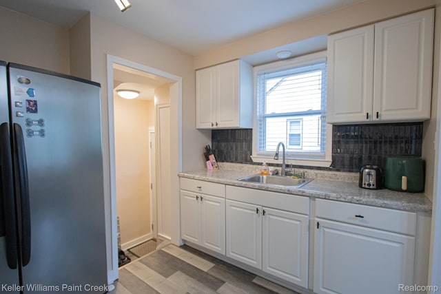 43 Canfield Dr, Mount Clemens, MI 48043 - kitchen with freestanding refrigerator, a sink, decorative backsplash, white cabinets, and light wood-type flooring