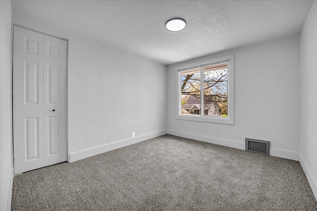 2061 E Whittemore Ave, Burton, MI 48529 - spare room with baseboards, carpet flooring, a textured ceiling, and visible vents