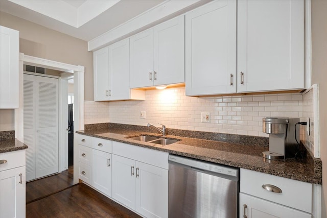 kitchen featuring dark stone counters, a sink, and dishwasher