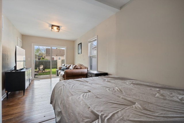 bedroom with wood finished floors and access to exterior