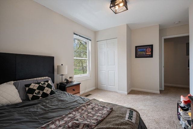 carpeted bedroom with baseboards, visible vents, and a closet