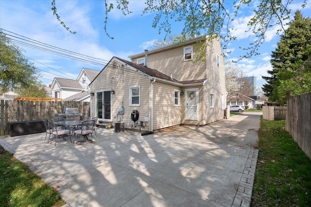 rear view of property featuring fence and a patio