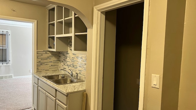 interior space with visible vents, light countertops, tasteful backsplash, a sink, and carpet