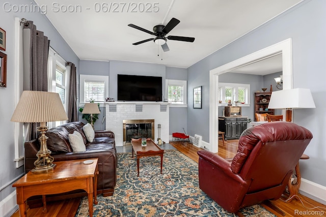 879 Lawrence St, Detroit, MI 48202 - living area featuring wood finished floors, a ceiling fan, and a fireplace