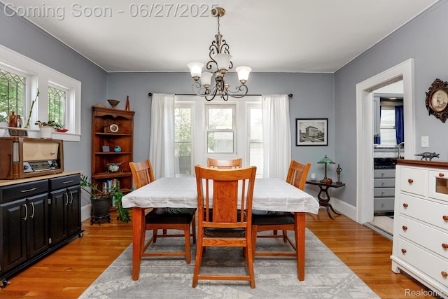 879 Lawrence St, Detroit, MI 48202 - dining room featuring a chandelier, light wood-type flooring, and crown molding