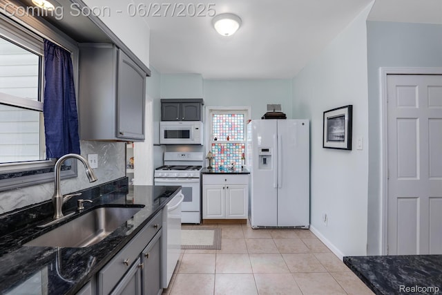 879 Lawrence St, Detroit, MI 48202 - kitchen featuring white appliances, dark stone countertops, light tile patterned floors, gray cabinetry, and backsplash