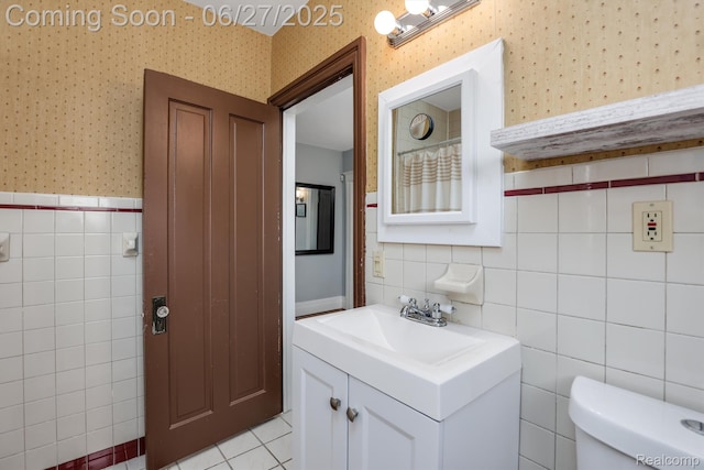 879 Lawrence St, Detroit, MI 48202 - bathroom with wallpapered walls, vanity, tile walls, a wainscoted wall, and tile patterned floors