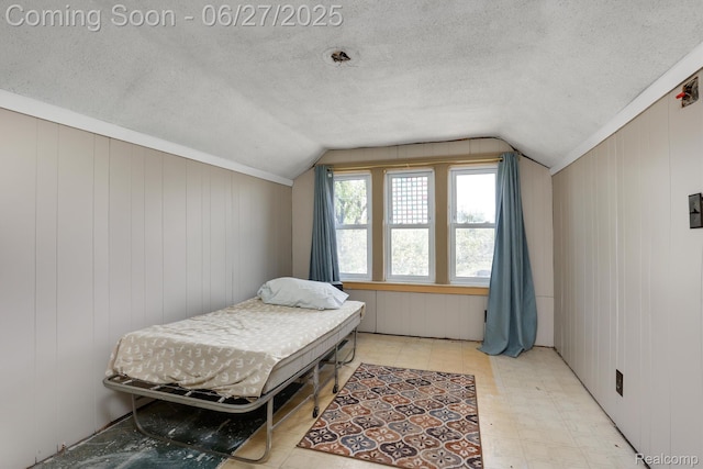 879 Lawrence St, Detroit, MI 48202 - bedroom featuring lofted ceiling, light floors, a textured ceiling, and wood walls