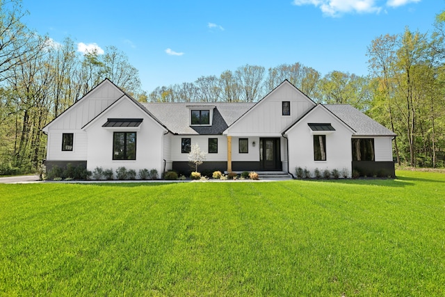 modern farmhouse featuring board and batten siding, a front yard, and a shingled roof