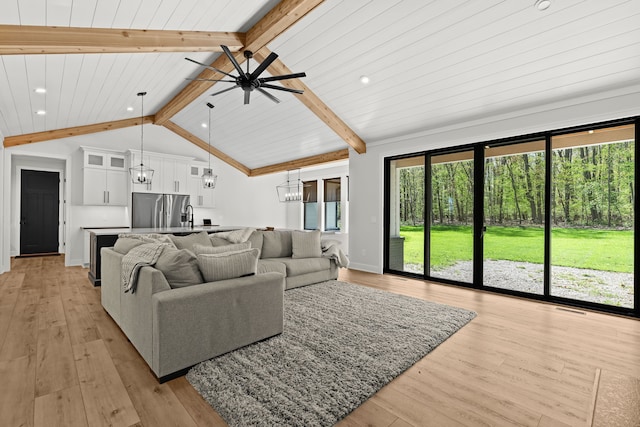 living room with a chandelier, a ceiling fan, recessed lighting, light wood-style floors, and baseboards