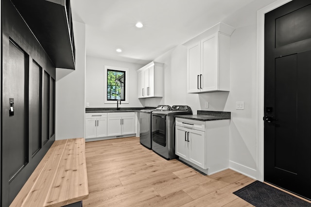 kitchen featuring washer and clothes dryer, light wood-style flooring, white cabinets, a sink, and recessed lighting