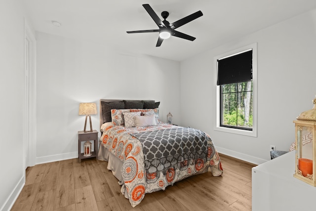 bedroom with light wood-style flooring, baseboards, and ceiling fan