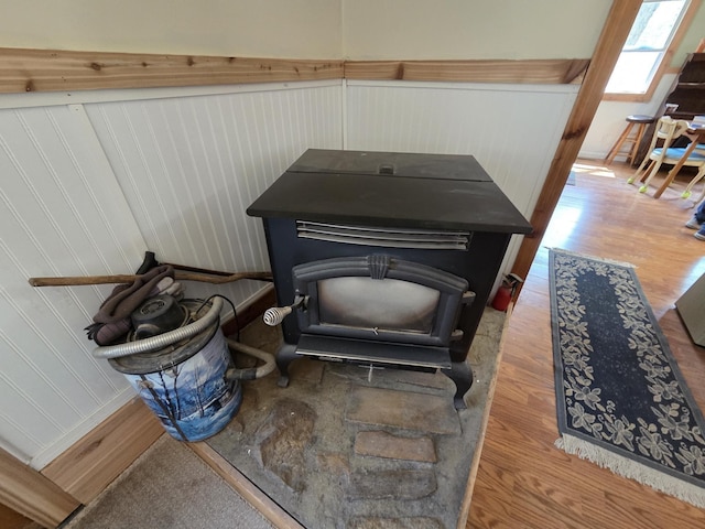 4280 Birch St, Lake, MI 48632 - detailed view of wood finished floors, a wood stove, and a wainscoted wall