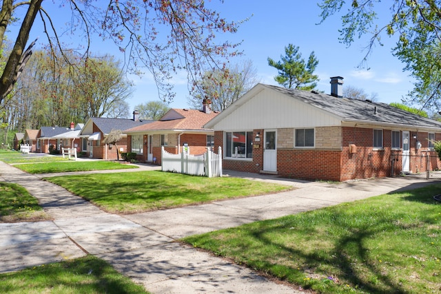 single story home with fence, a front lawn, and brick siding