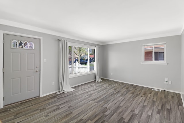 foyer entrance featuring crown molding, baseboards, visible vents, and wood finished floors