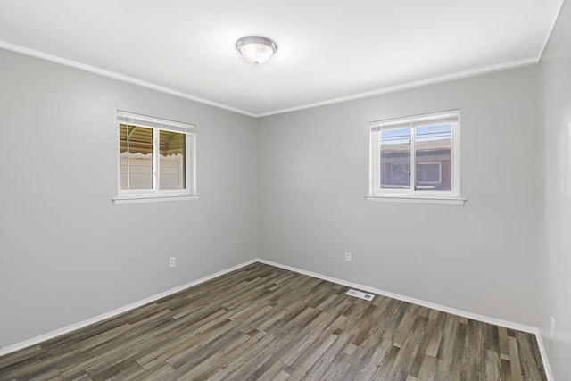 unfurnished room featuring crown molding, baseboards, wood finished floors, and a healthy amount of sunlight