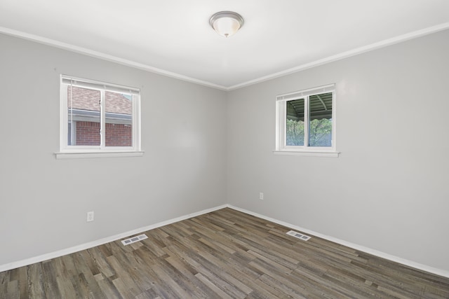 unfurnished room with visible vents, plenty of natural light, and wood finished floors