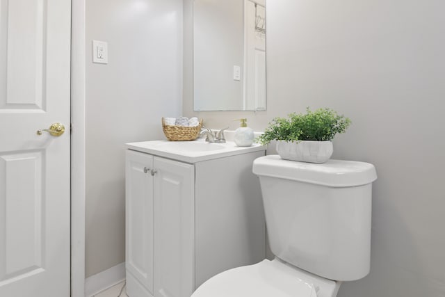 half bath featuring vanity and toilet