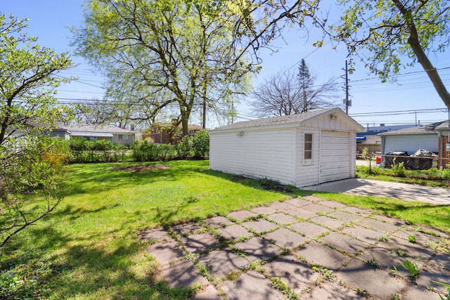 view of yard with a detached garage, fence, and an outdoor structure