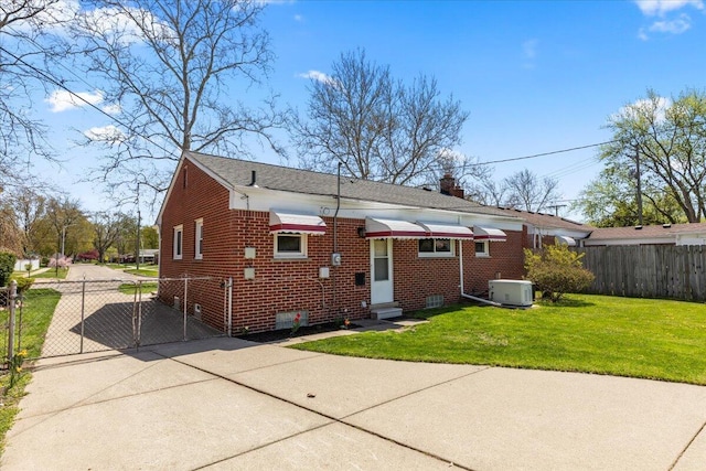 rear view of property featuring fence, central AC, entry steps, a gate, and driveway