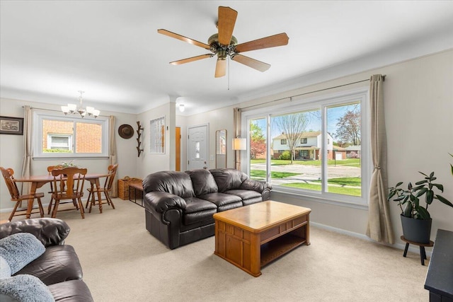 living room with light colored carpet, baseboards, and ceiling fan with notable chandelier