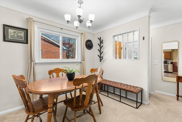 dining space featuring an inviting chandelier, baseboards, and light carpet