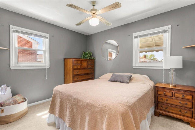 bedroom featuring light colored carpet, baseboards, and ceiling fan