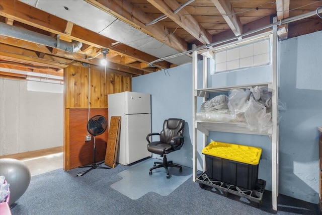 below grade area featuring freestanding refrigerator