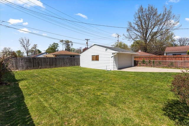 view of yard with a fenced backyard, a detached garage, an outdoor structure, and a patio