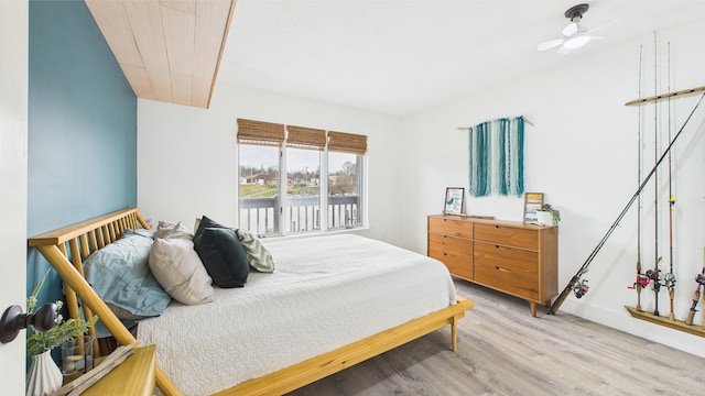 bedroom featuring a water view and wood finished floors